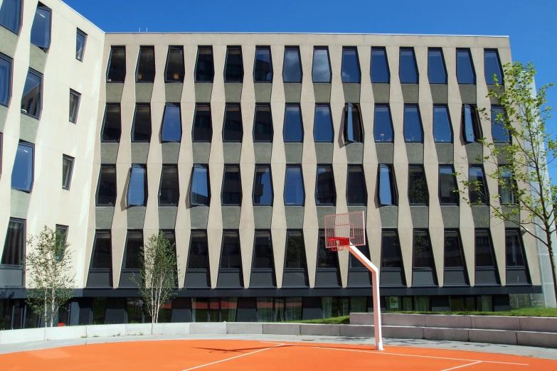 an outdoor basketball court in front of a building