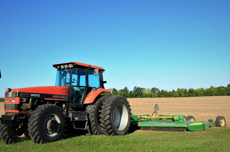 a tractor is parked next to a large farm machinery