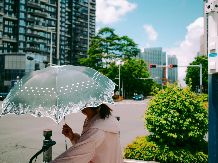 a woman is holding an umbrella outside while looking at her phone