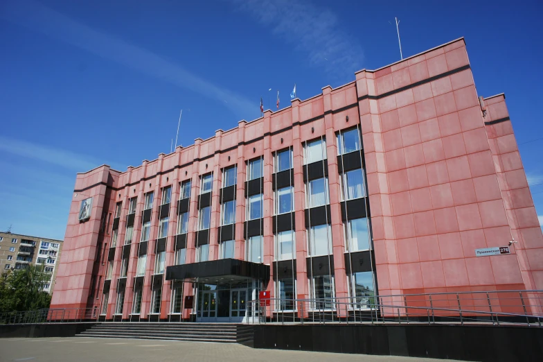 large orange building with windows next to a walkway