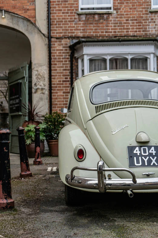 an old fashioned vw bug parked near a building