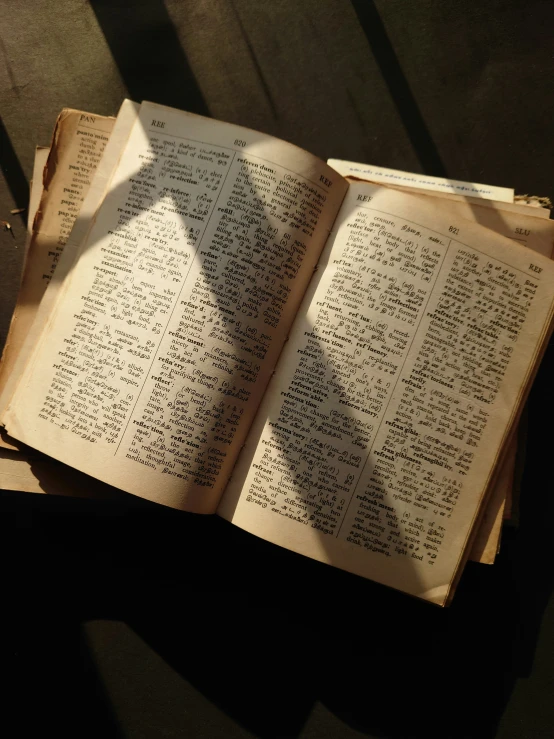 an old book on the floor with words written on it