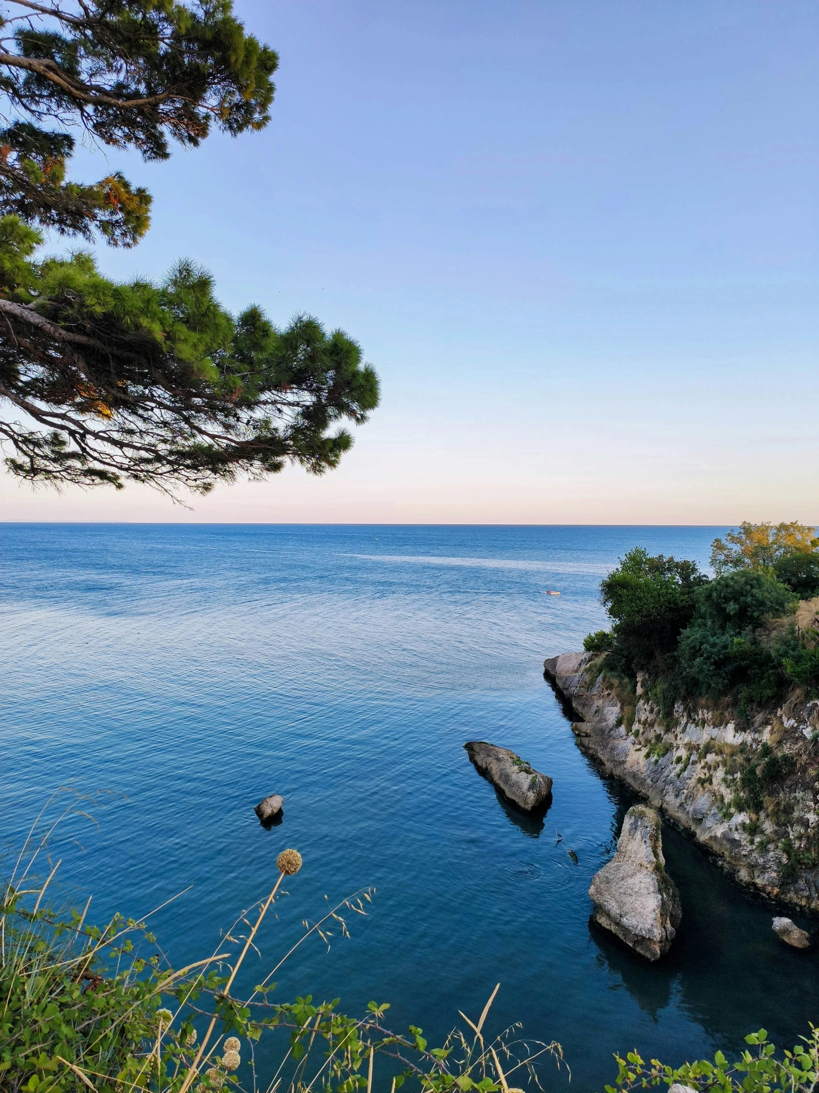 several rock outcroppings on the edge of a body of water