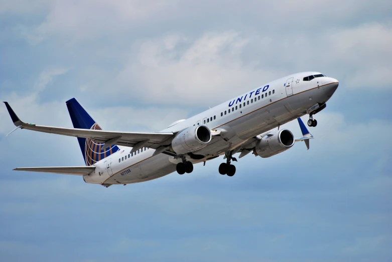 an airplane is flying in the air against a cloudy blue sky