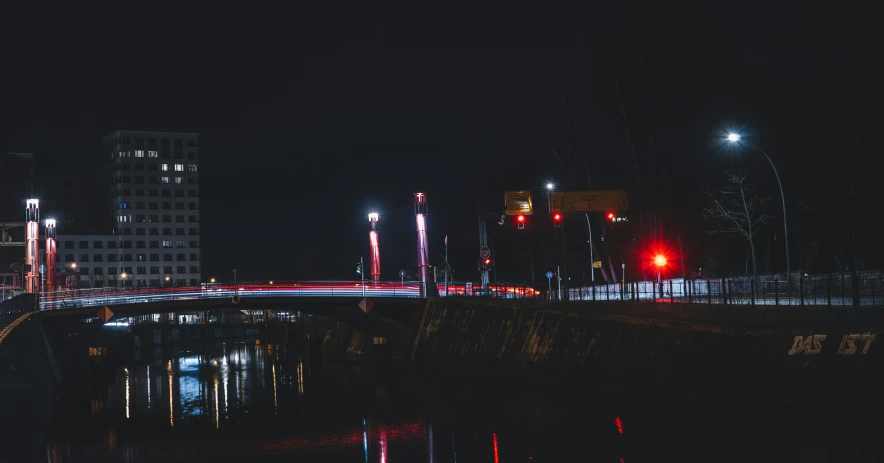 a bridge at night with street lights reflecting in the water