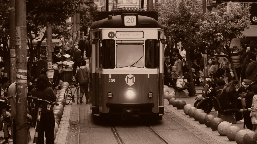 a black and white image of a trolley train going through town