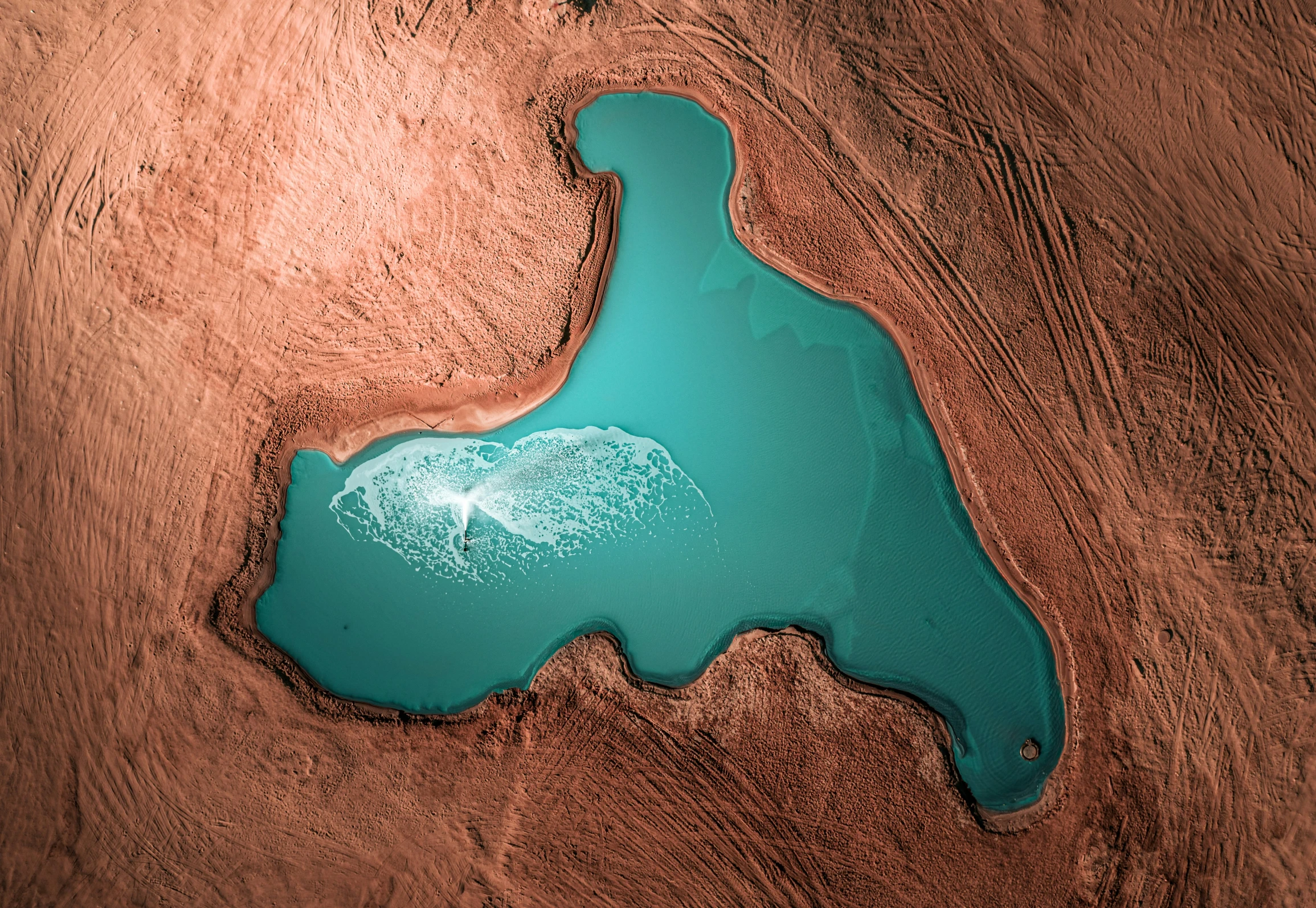 a lake in a valley surrounded by sandy terrain