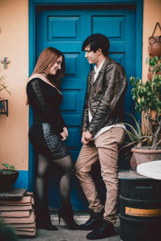 man in brown jacket standing next to woman in black