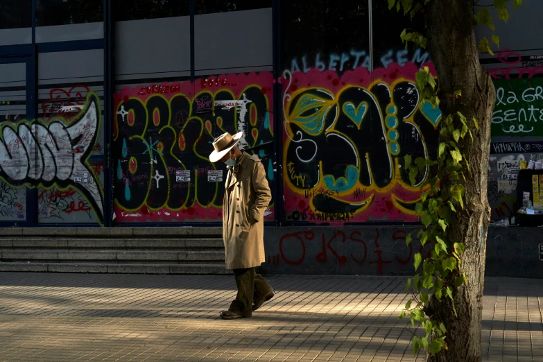 a man walking down a street in front of a building