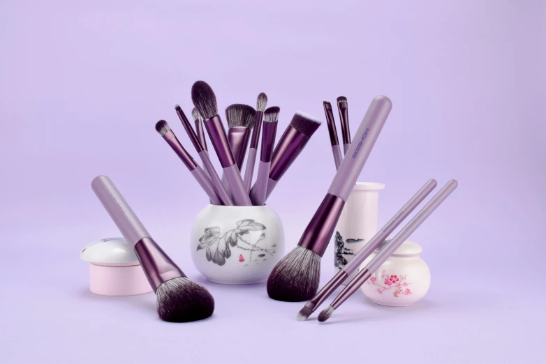 a group of makeup brushes sitting inside of a white container