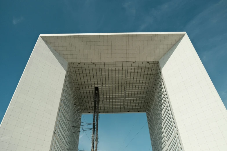 looking up at the side of a tall structure with a sky background