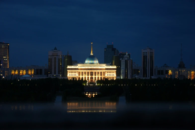 a city night scene from across the lake with buildings lit up