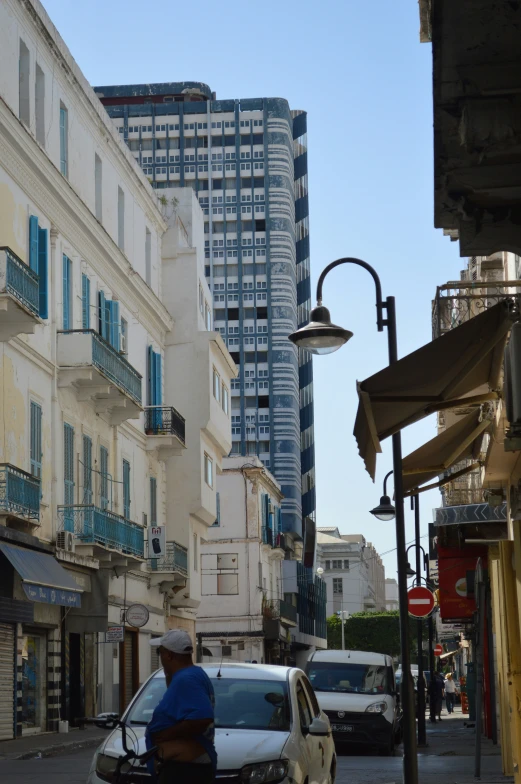 a man walking down a street between tall buildings