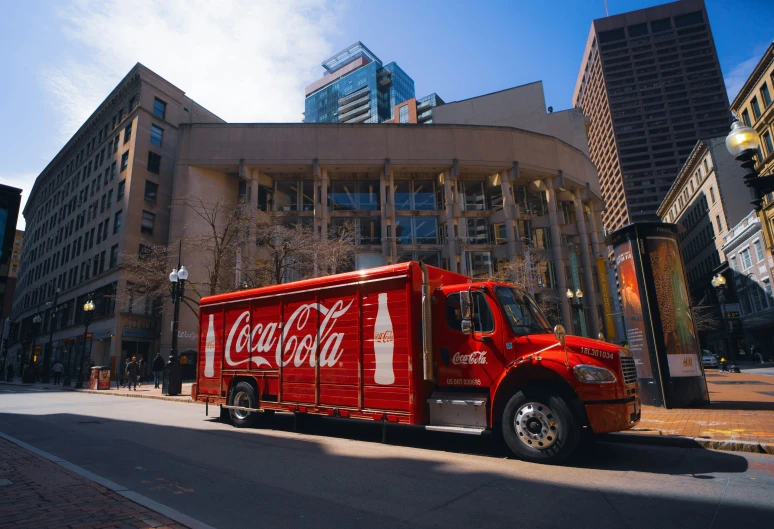 a truck with coca cola on the side on the road