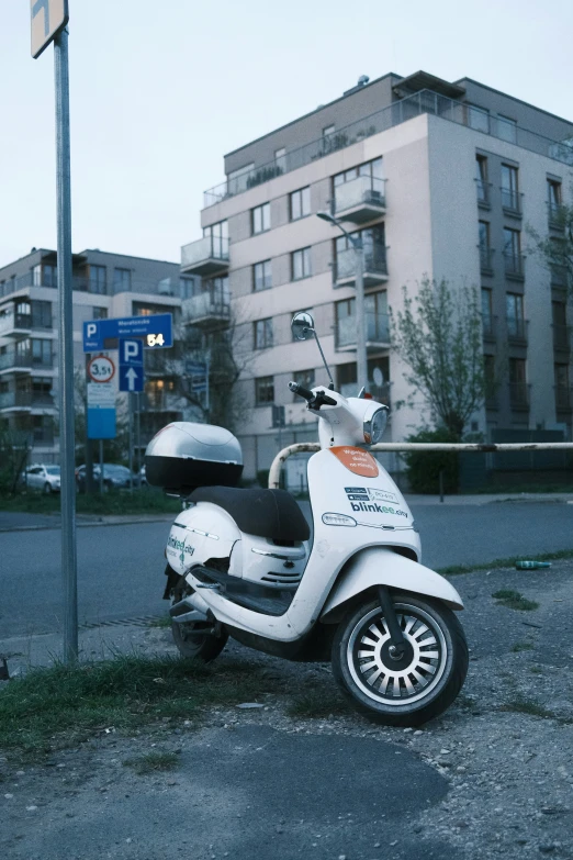 a white scooter parked on the side of a street