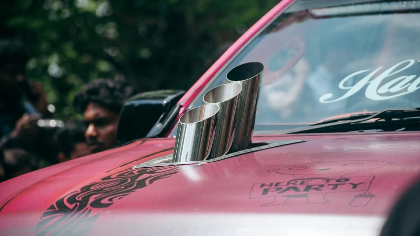 a close up of a red car with chrome on the hood