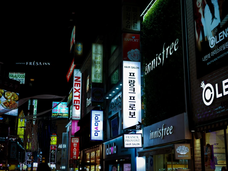 an asian street filled with colorful lit signs at night