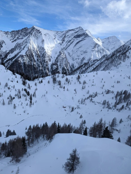 the mountains covered with snow are seen under a blue sky