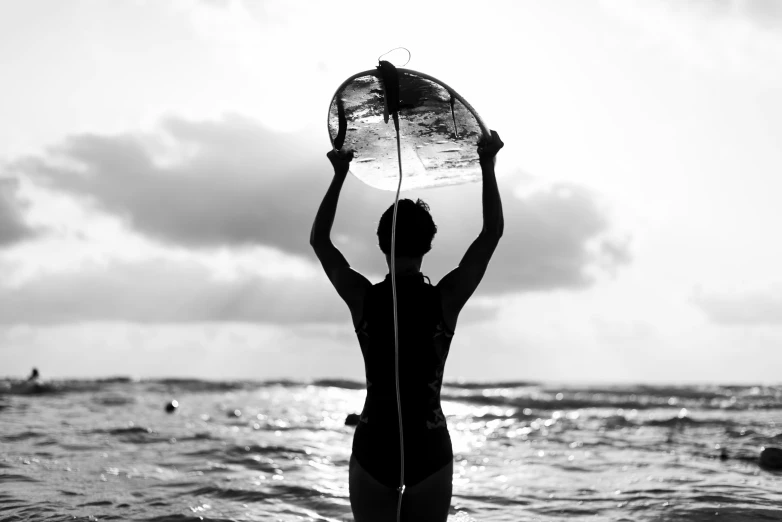 a woman standing on the beach while holding up a net