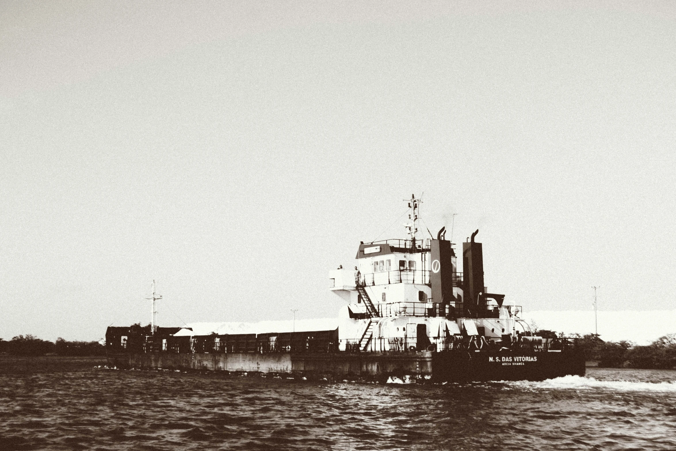 a boat sails down the ocean water with other ships nearby