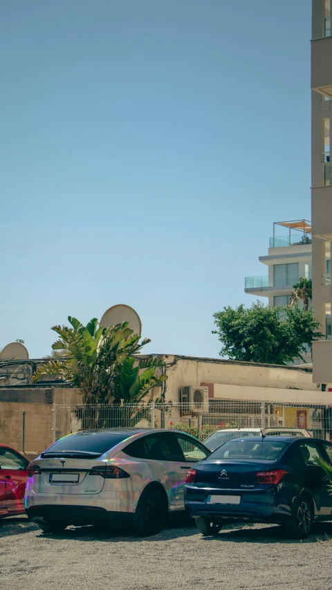 a group of cars parked on a gravel parking lot