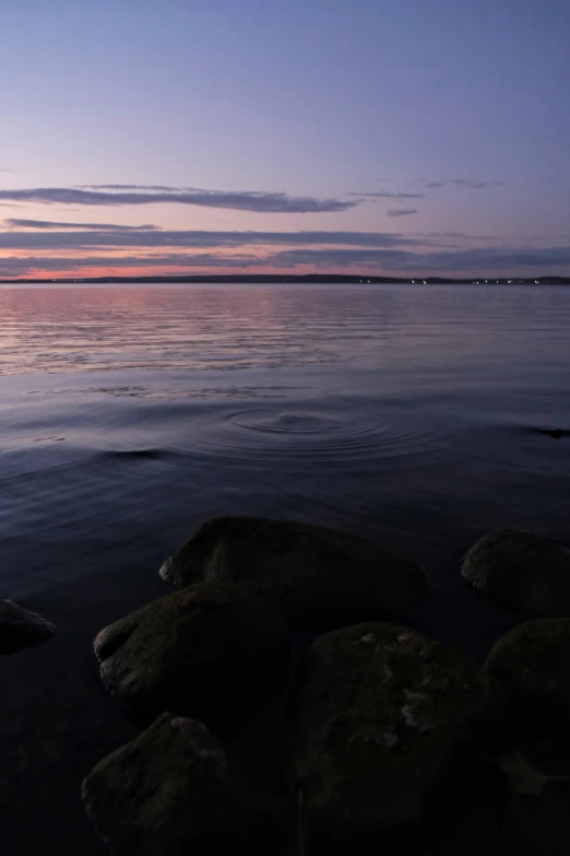 sunset at a beach on the water with rocks