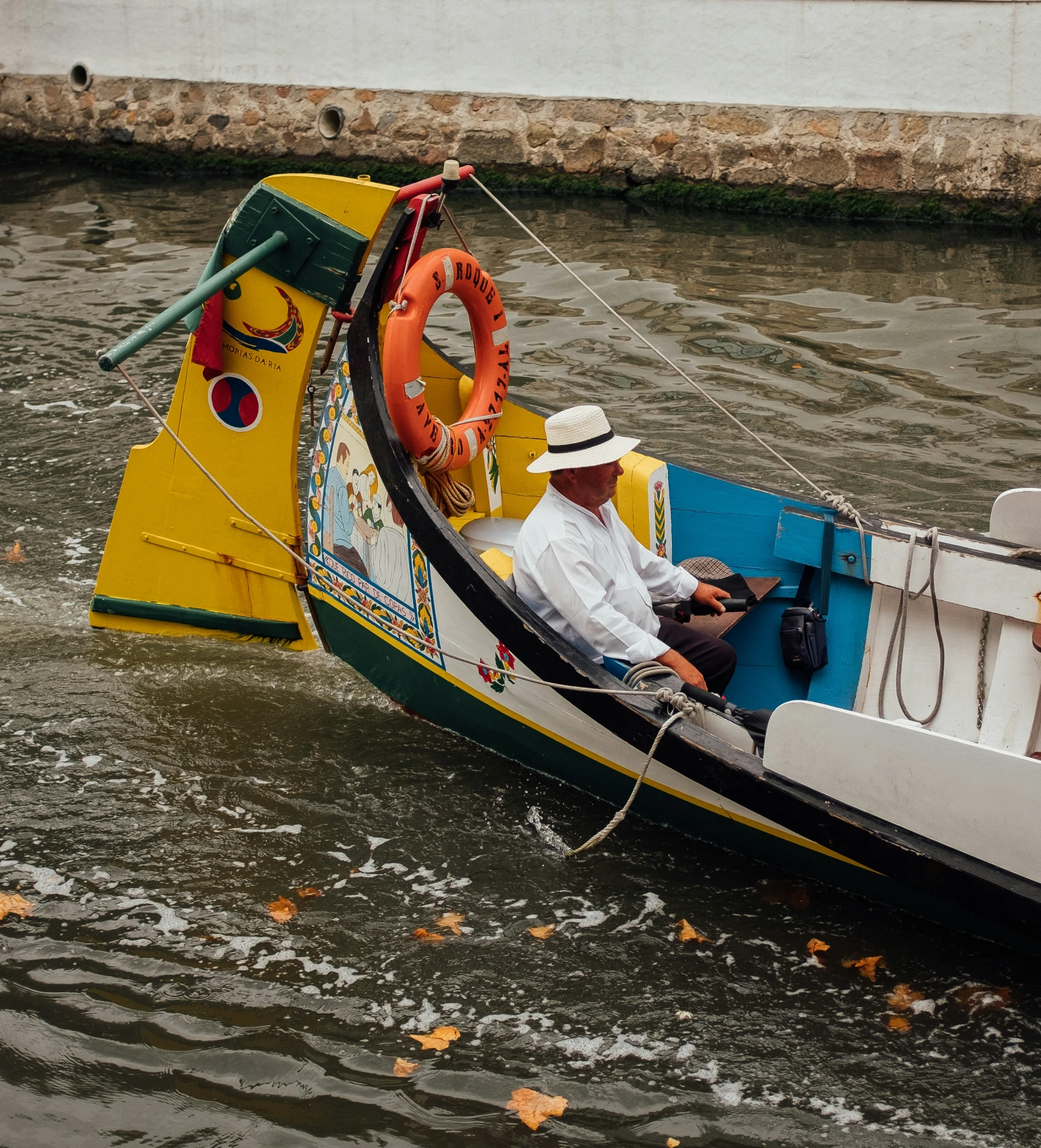 the man sits in his small boat on the water