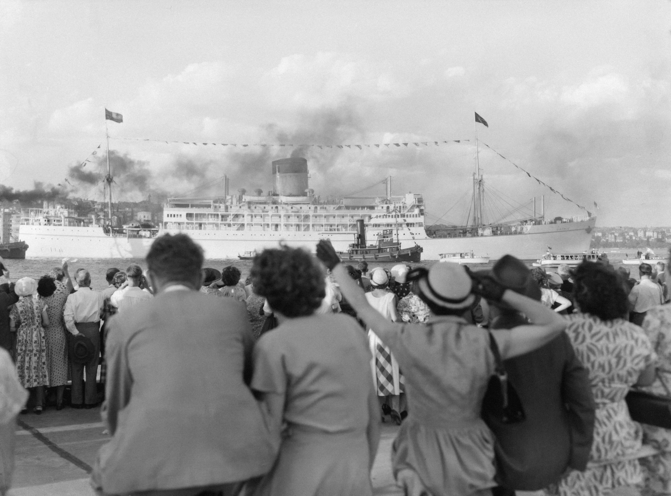 a crowd of people watching a steamboat being launched