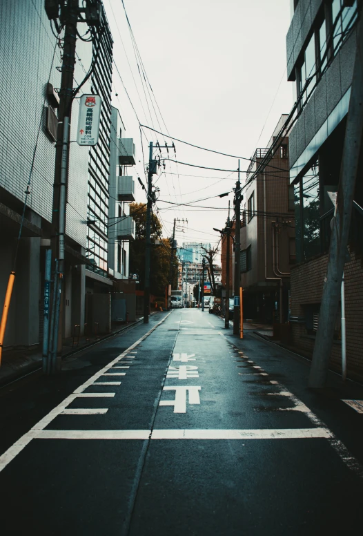 a narrow street lined with tall buildings next to street signs