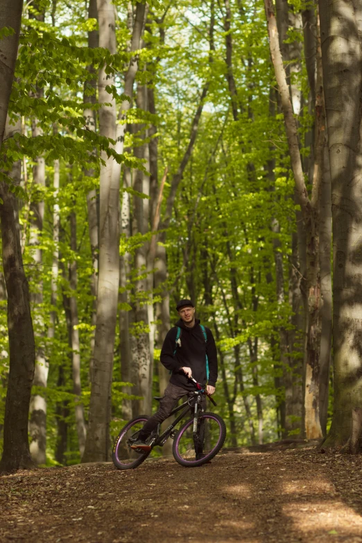 a man in a black jacket and helmet riding a bicycle