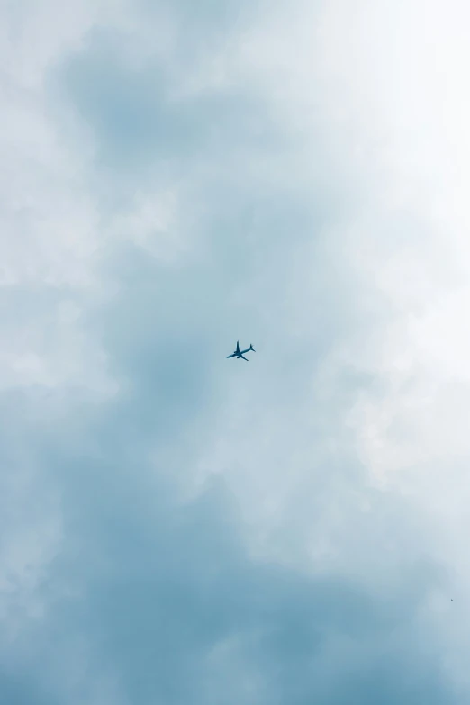 the jet is flying in the blue cloudy sky