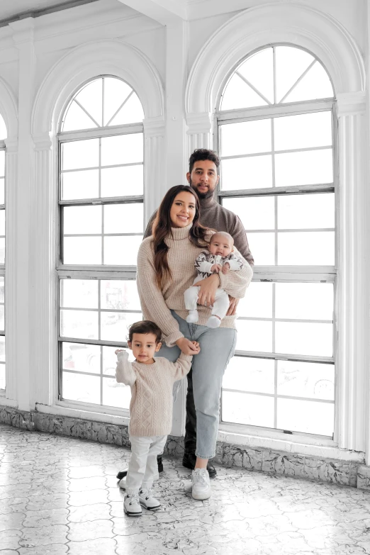 a man and a woman with their children in the white room