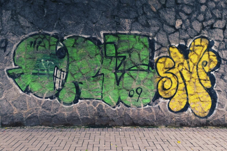 some graffiti art on a concrete wall with grass
