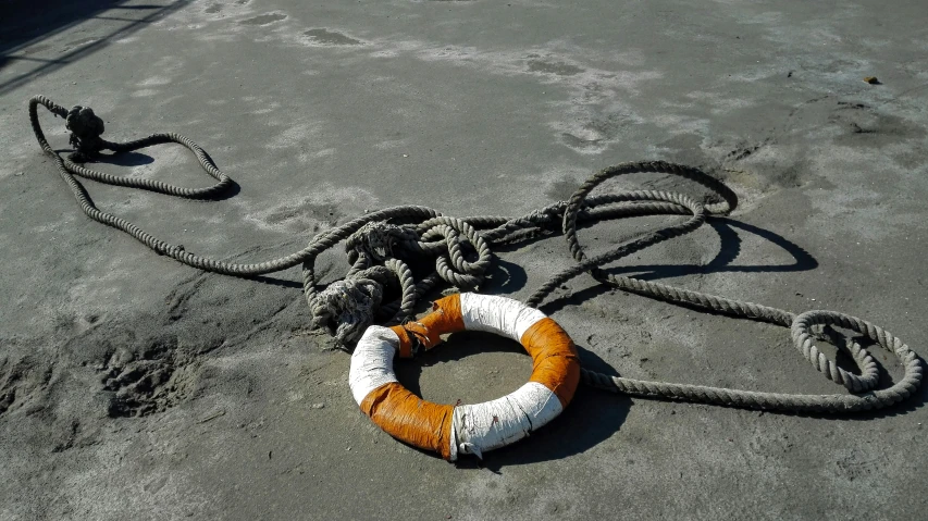 a rope on the ground with orange and white ropes