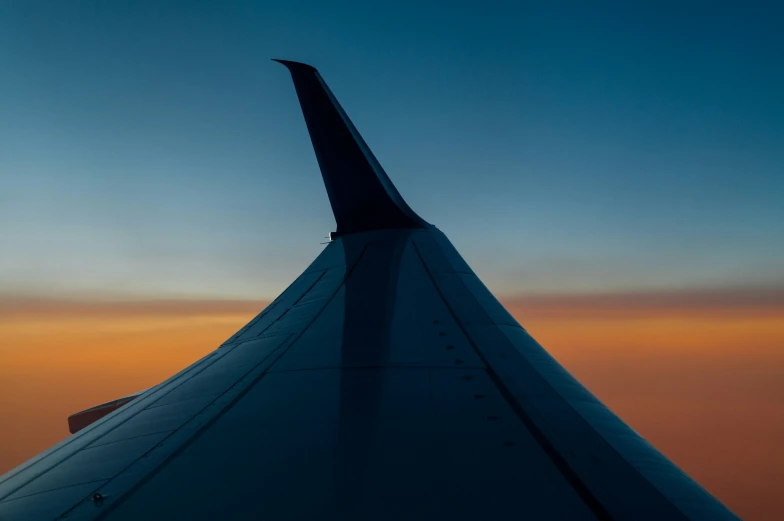 an airplane wing with the sky in the background