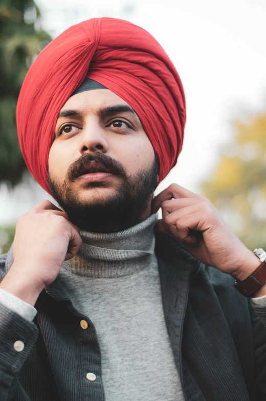 an indian man wearing a red turban with hair pulled back