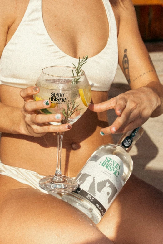 a woman is holding a cocktail while sitting on the ground