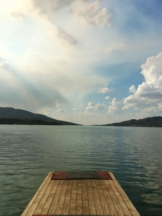 the wooden dock extends to a large body of water