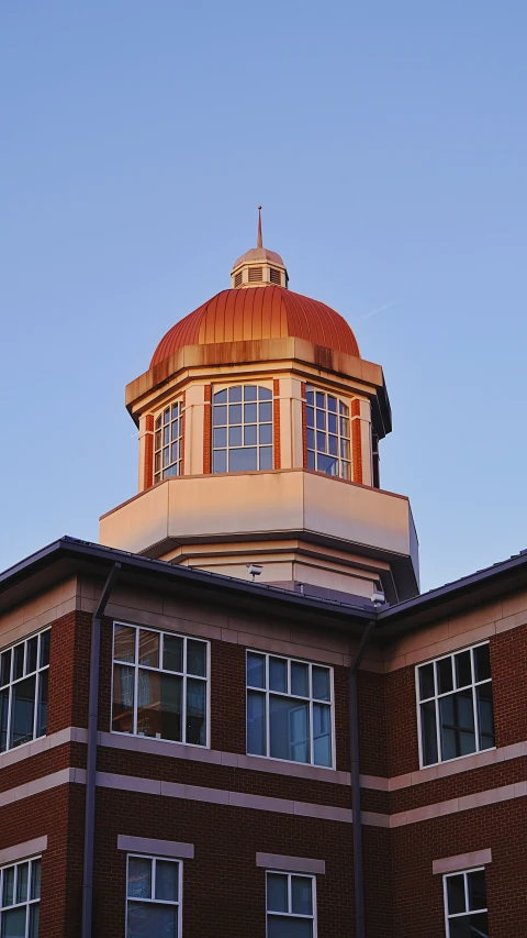 a round tower with lots of windows is located on top of a building