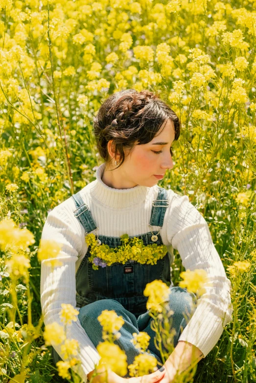 a woman sitting in a field of flowers