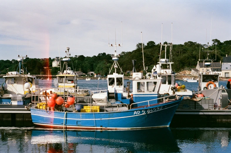 three small boats moored to the docks near a town