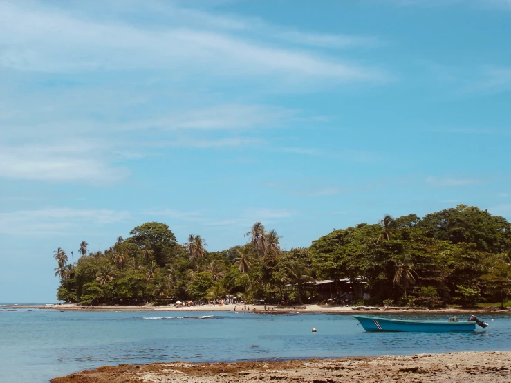 boats are anchored on the beach by the water