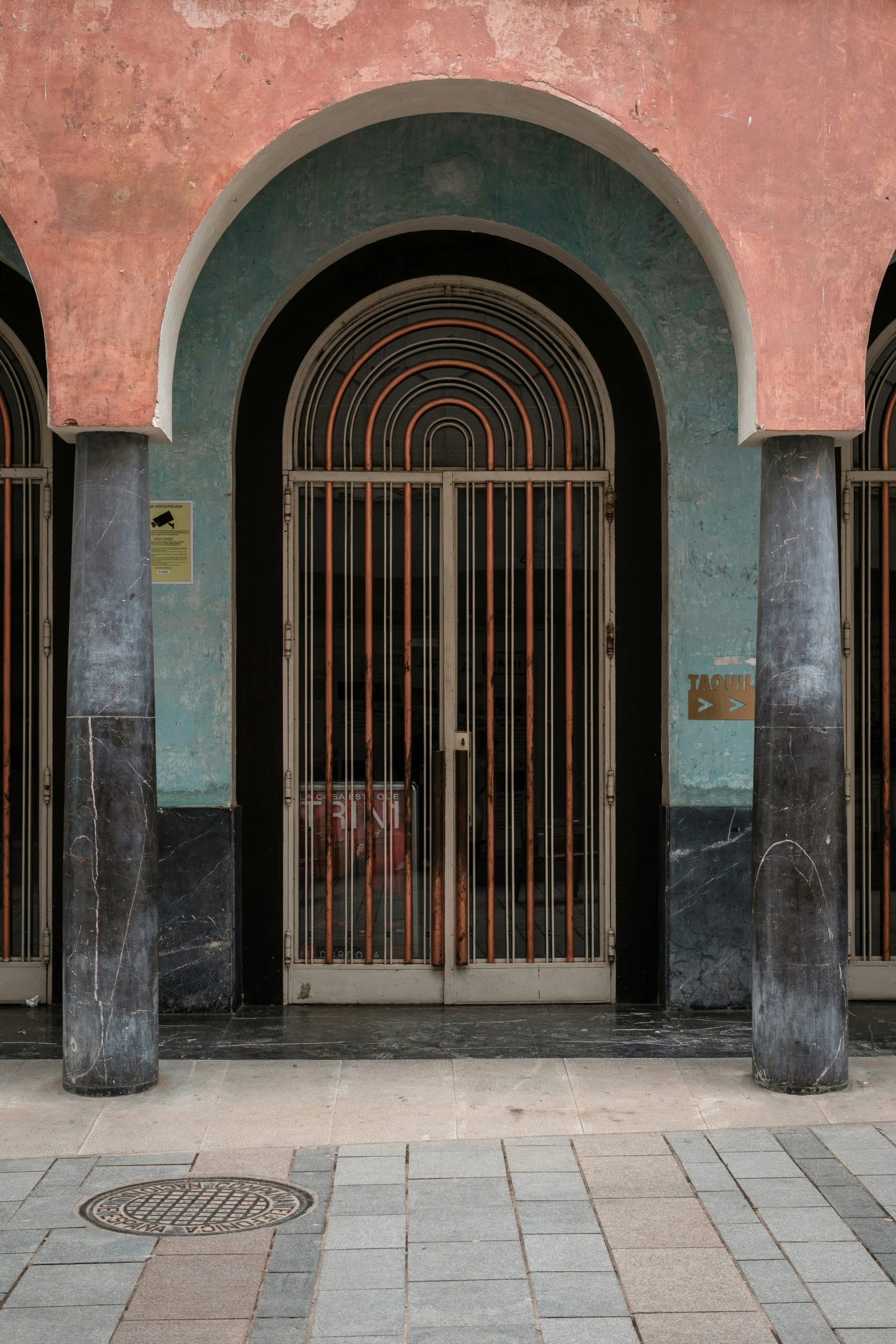 a red and green building with metal doors on it