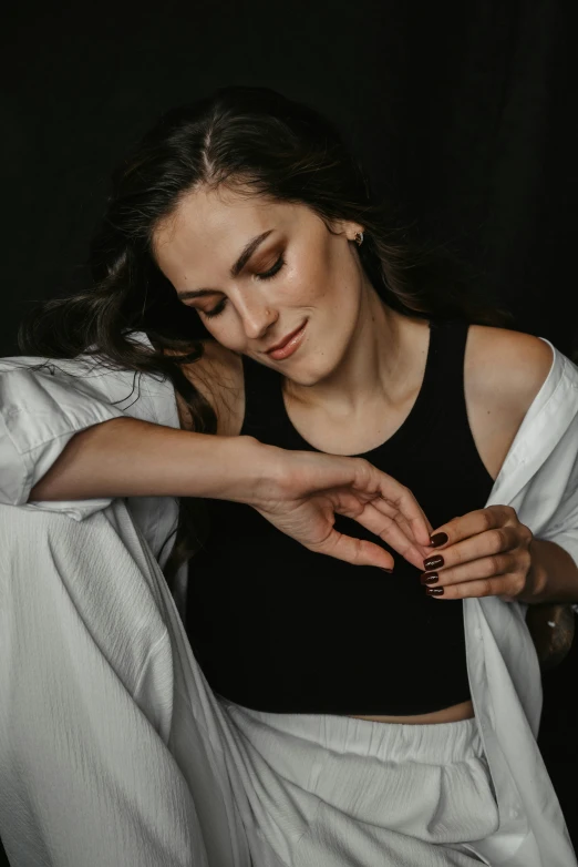 a woman looking down at her dress while holding onto a jacket