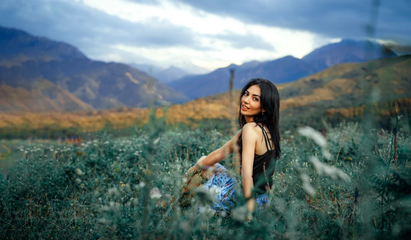 the young woman is in the middle of a green field