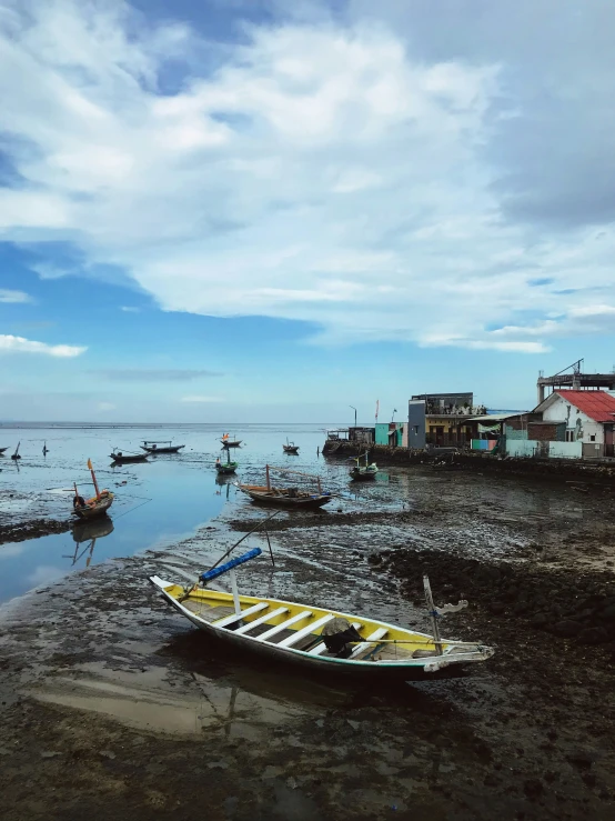 a beach with several boats and people in the water