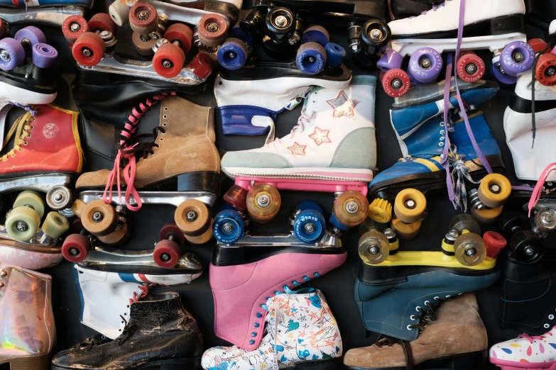 some very colorful roller skates are sitting on a pile