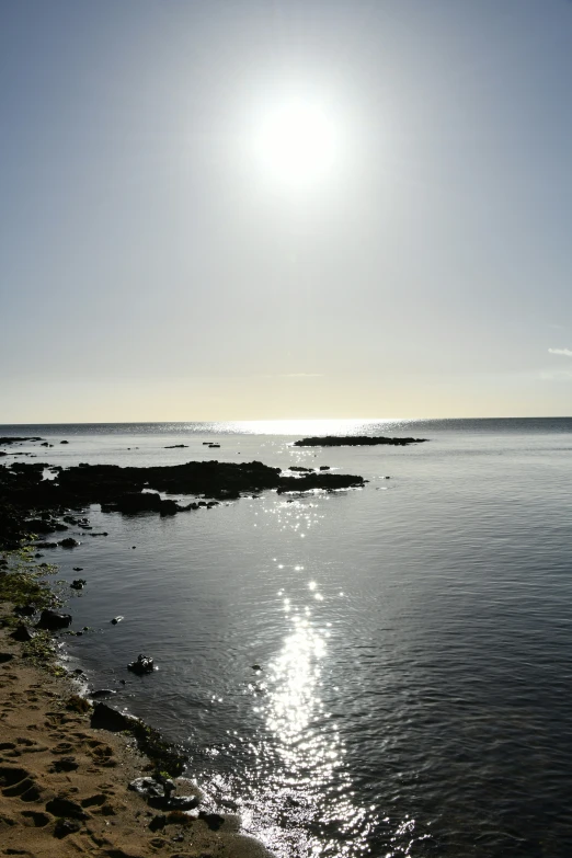 the ocean with rocks and water under a clear sky