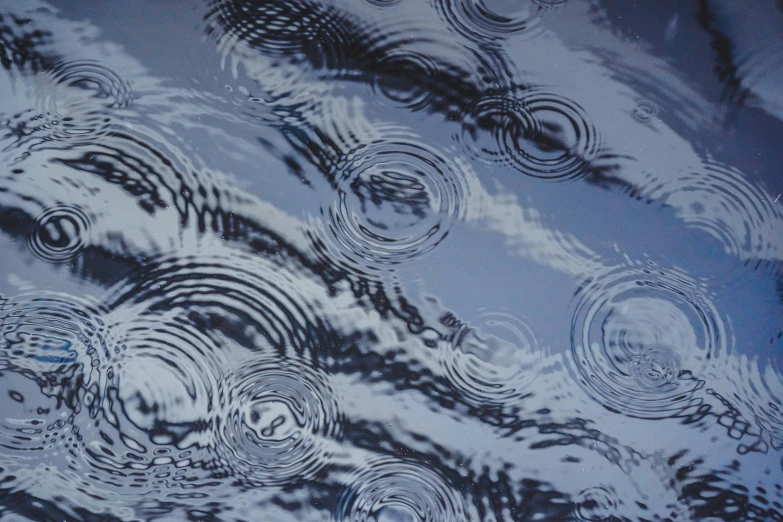an abstract image of patterns on water with a black background