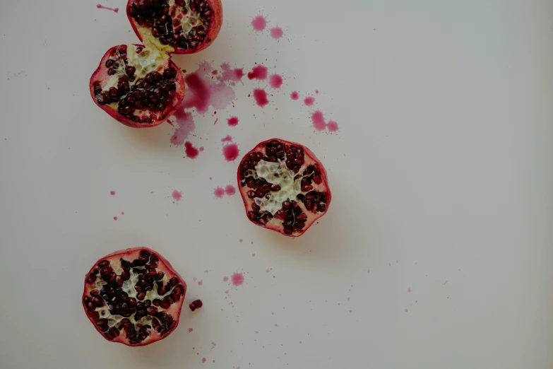 two pieces of pomegranate that have spilled on the table